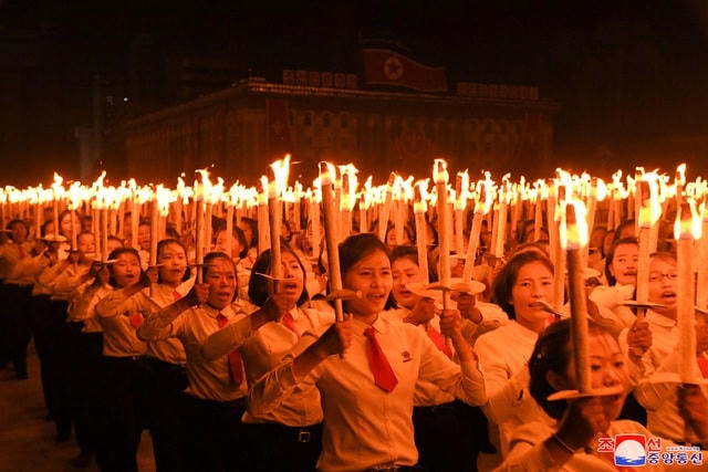 Người Triều Tiên cầm đuốc xếp thành các khối hình và khẩu hiệu trong lễ duyệt binh.