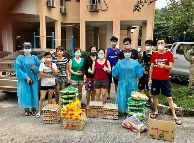 Đại diện Ban liên lạc và Câu lạc bộ Phụ nữ Việt Nam tại Malaysia trao quà hỗ trợ đến bà con gặp khó khăn.