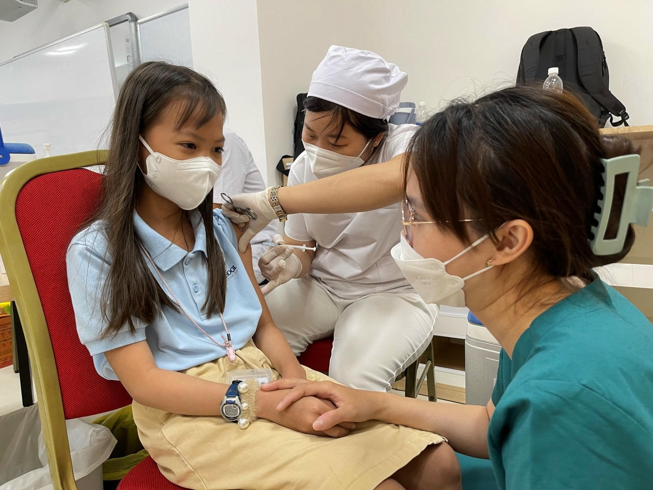 Nhân viên y tế trò chuyện để giảm lo sợ cho trẻ khi tiêm vaccine Covid-19.