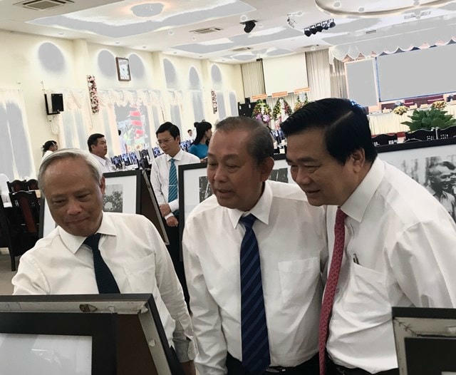 Phó Thủ tướng Thường trực Chính phủ Trương Hòa Bình (giữa) cùng Phó Chủ tịch Quốc hội Uông Chu Lưu (trái) và đại biểu xem triển lãm một số hình ảnh về cuộc đời và sự nghiệp của đồng chí Nguyễn Hữu Thọ bên lề hội thảo.