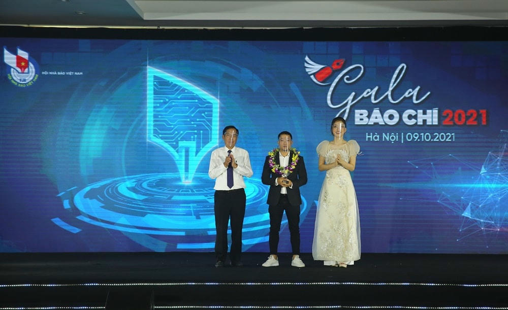 Ông Thuận Hữu - Chủ tịch Hội Nhà báo Việt Nam, Á hậu Bùi Phương Nga công bố và trao giải tác phẩm ảnh báo chí đạt Giải ấn tượng trong Giải ảnh “Khoảnh khắc báo chí 2020” cho tác giả Phạm Ngọc Thành – Báo Báo Điện tử VnExpress với tác phẩm “Tìm kiếm nạn nhân lở núi ở Trà Leng”. Ảnh: Sơn Hải