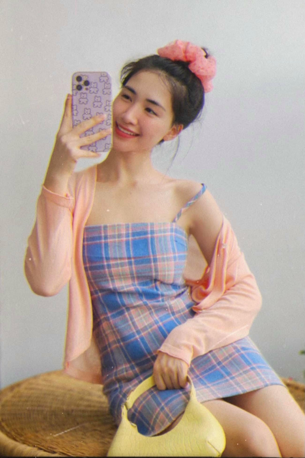 Với chiếc váy cảo và áo khoát cardigan màu hồng nhạt, Hòa khéo léo kết hợp crunchies buộc tóc cùng màu trông rất nhẹ nhàng và nhí nhảnh.