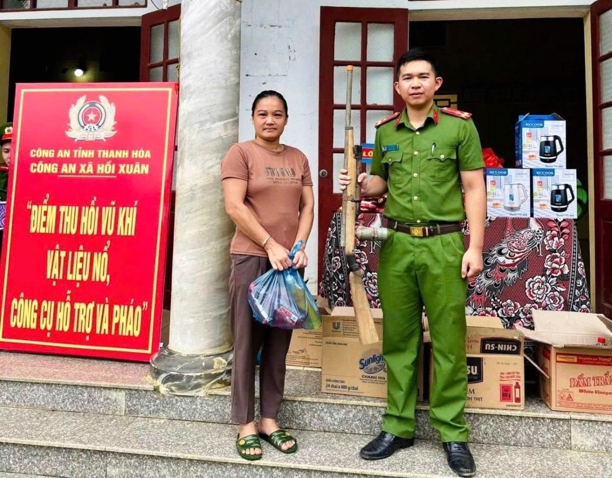 Người dân xã Hồi Xuân giao nộp các loại vũ khí và nhận lại phần quà ý nghĩa. Ảnh: Nguyễn Chung