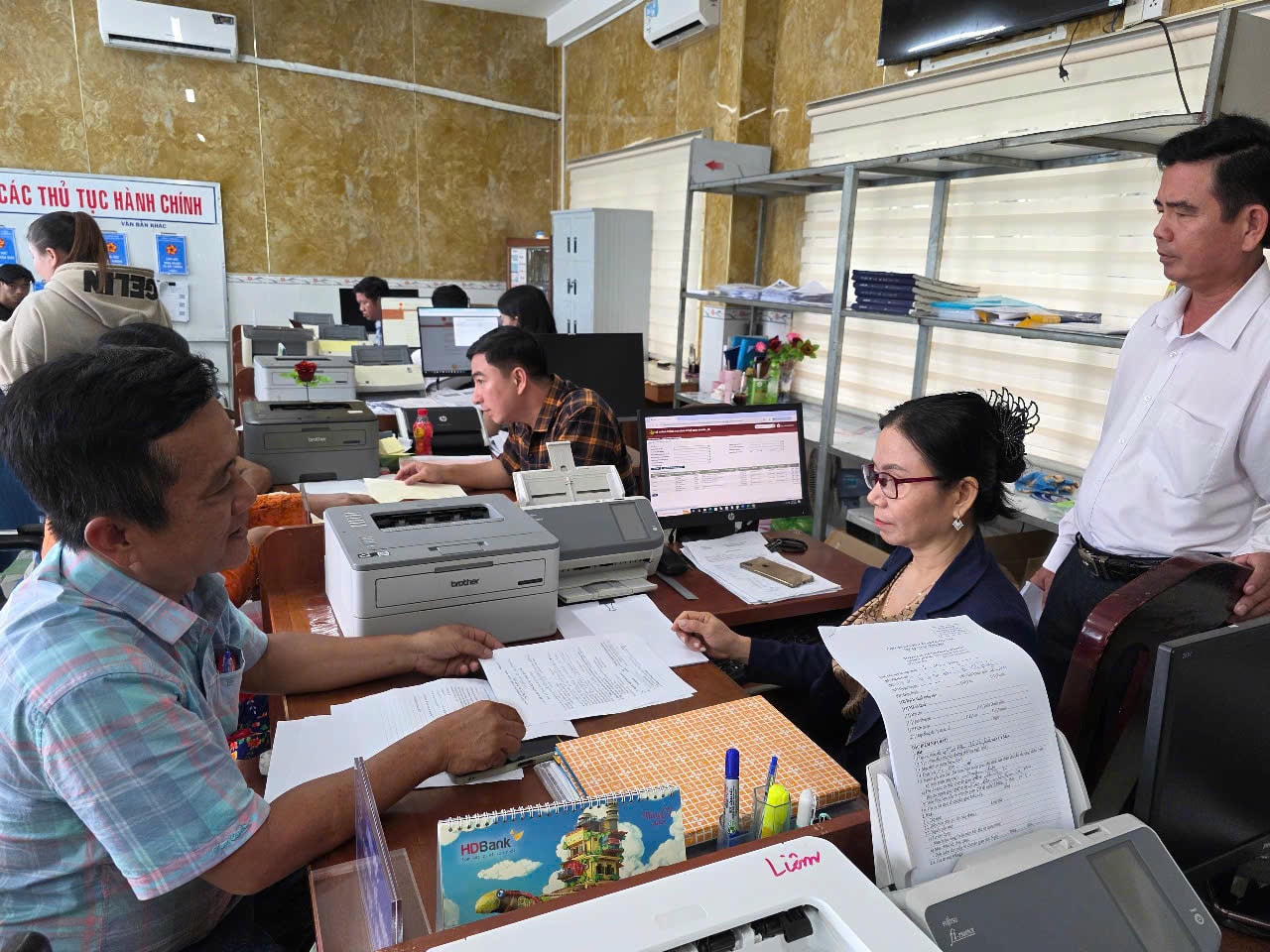 ẢNH 5 Trương Văn Dũng (áo sọc), người dân sinh sống tại địa bàn, đánh giá cao thái độ phục vụ và quy trình xử lý công việc của cán bộ xã Vĩnh Phước.