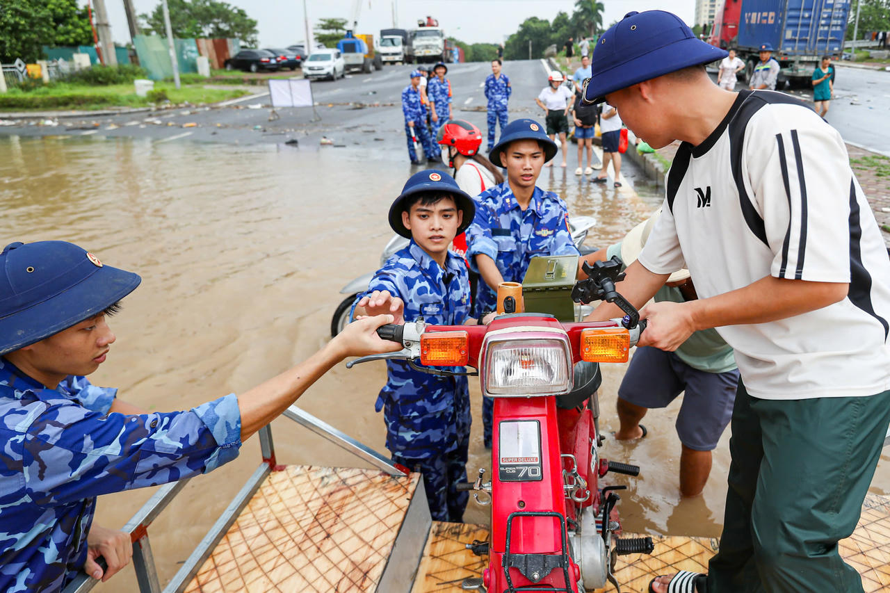 Lực lượng Cảnh sát biển hỗ trợ người dân đưa xe lên phà.