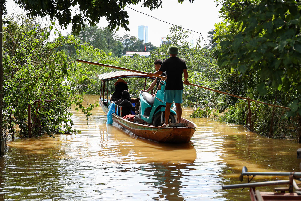 Từng con thuyền liên tục đưa người dân ra khỏi vùng ngập.