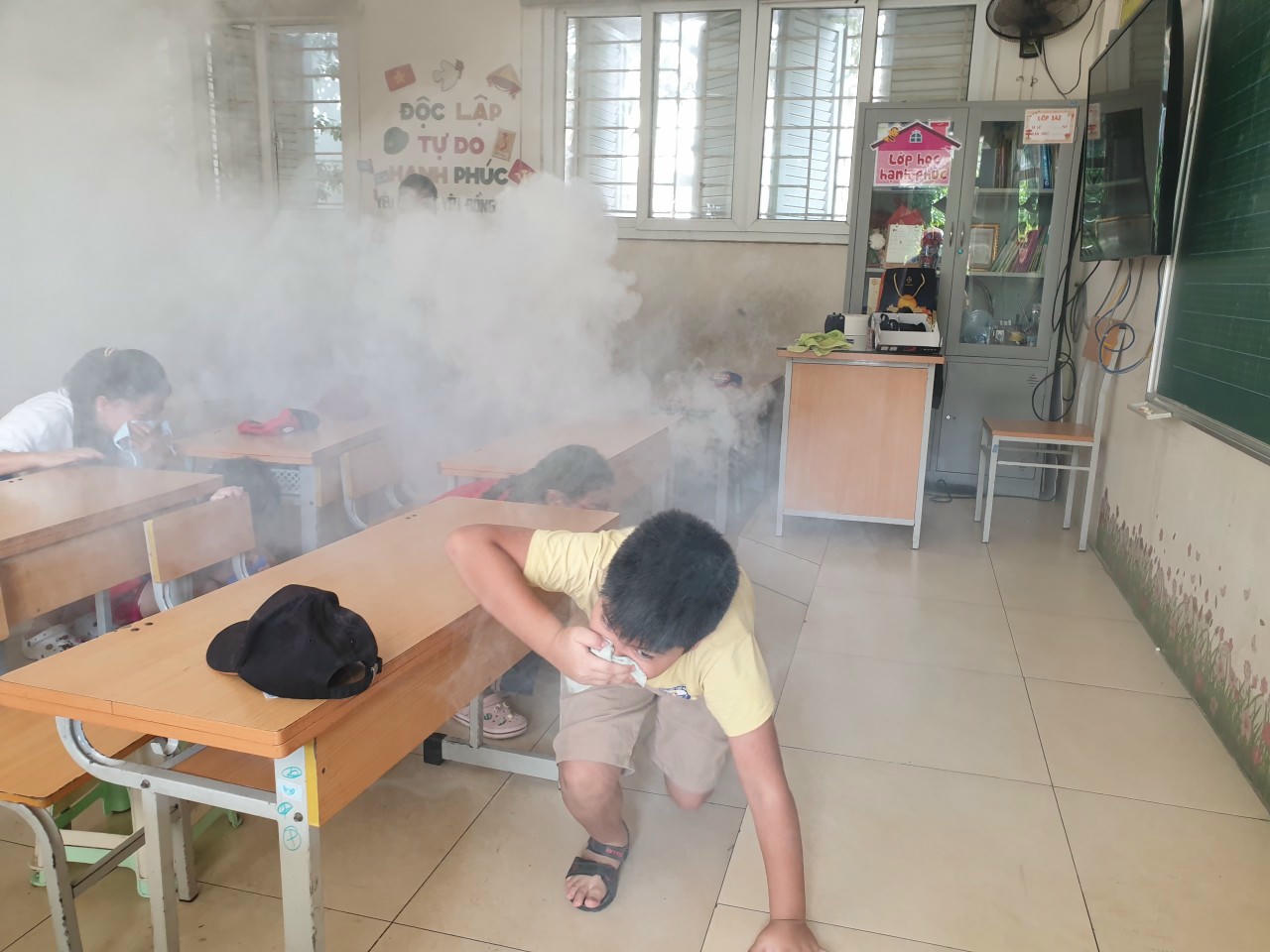 Công an TP Hà Nội hướng dẫn học sinh Trường Tiểu học Đại Kim (Hà Nội) thoát khỏi đám cháy trong buổi tuyên truyền về kỹ năng phòng cháy chữa cháy. 
