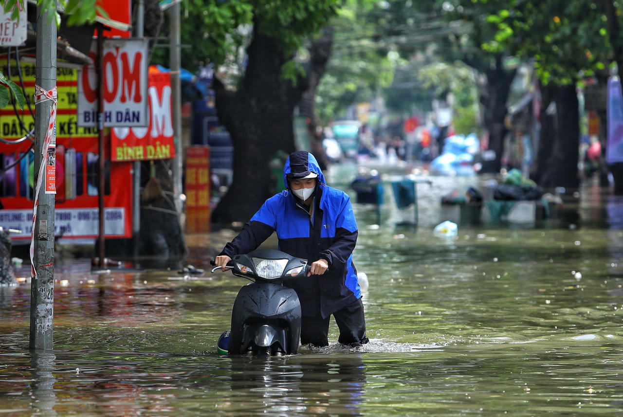Người dân vất vả vượt qua ngập úng tại phường Tây Mỗ (Hà Nội).