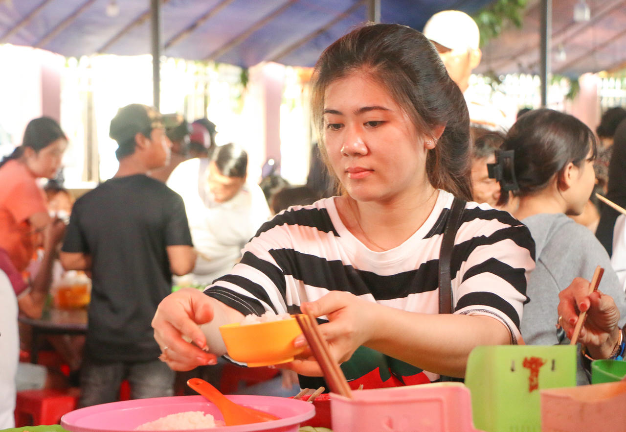 Người dân thưởng thức cơm chay miễn phí dịp lễ hội Nguyễn Trung Trực. Ảnh Nguyễn Minh.