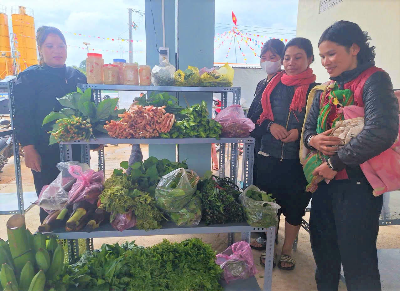 Chị Y Khương, ở thôn Ngọc Leng (ngoài cùng) cùng người dân tham gia bán hàng tại phiên chợ 0 đồng. Ảnh: Nguyễn Tín.