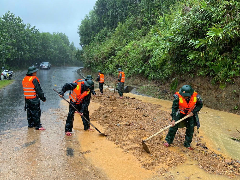 Bộ đội biên phòng thành phố Huế san gạt mặt đường bị sạt lở đất tại đèo Pê Kê, xã A Lưới 1. Ảnh: Mai Trang - TTXVN