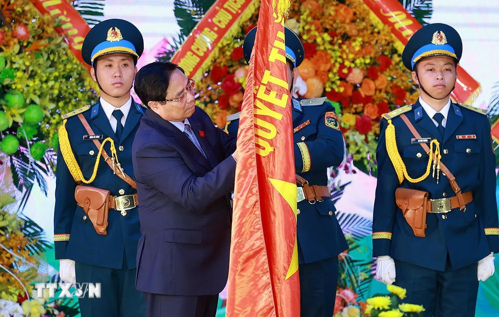 Thủ tướng Phạm Minh Chính gắn Danh hiệu Anh hùng Lực lượng Vũ trang Nhân dân lên Quân kỳ Quyết thắng của Quân chủng Phòng không-Không quân. (Ảnh: Dương Giang/TTXVN)