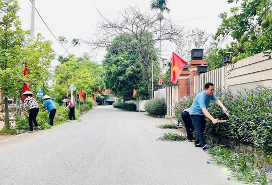 Người dân cắt tỉa cây, dọn dẹp vệ sinh đường làng ngõ xóm, tạo cảnh quan xanh, sạch, đẹp. Ảnh: Phương Thanh