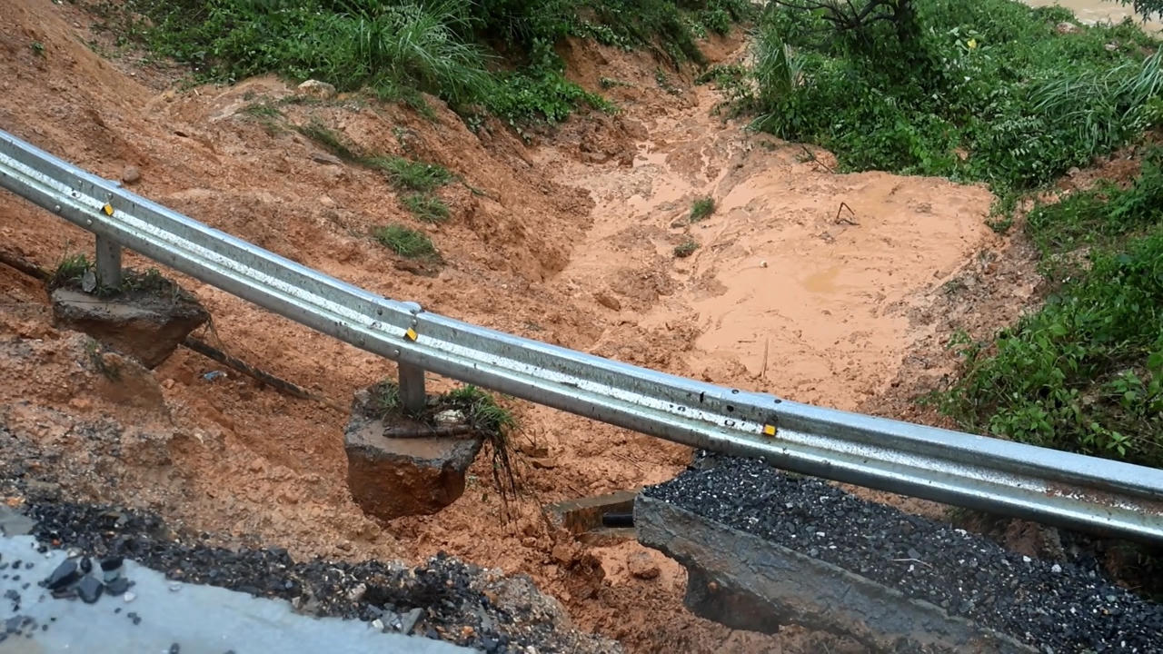 Sạt lở trên đường ĐT601 do lũ đổ về cuốn trôi đất ven bờ sông. Ảnh: Kim Hiếu.