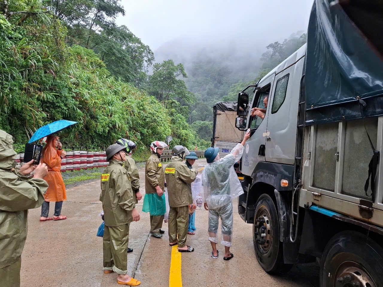 Công an xã xã Phước Năng phối hợp cảnh sát giao thông tặng nước uống, lương thực, mì tôm, bánh mì cho các tài xế và người dân đang mắc kẹt trên đèo. Ảnh: Công an xã.