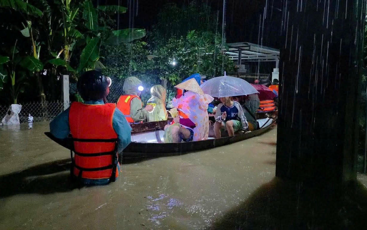 Lực lượng chức năng sử dụng ghe di chuyển người dân ra khỏi vùng ngập lụt sâu. Ảnh: C.Đại.