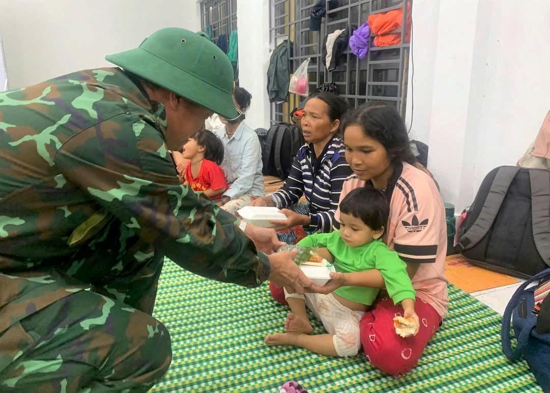 Lực lượng quân đội trao những suất cơm miễn phí cho người dân vùng lũ. Ảnh: T. Thành.