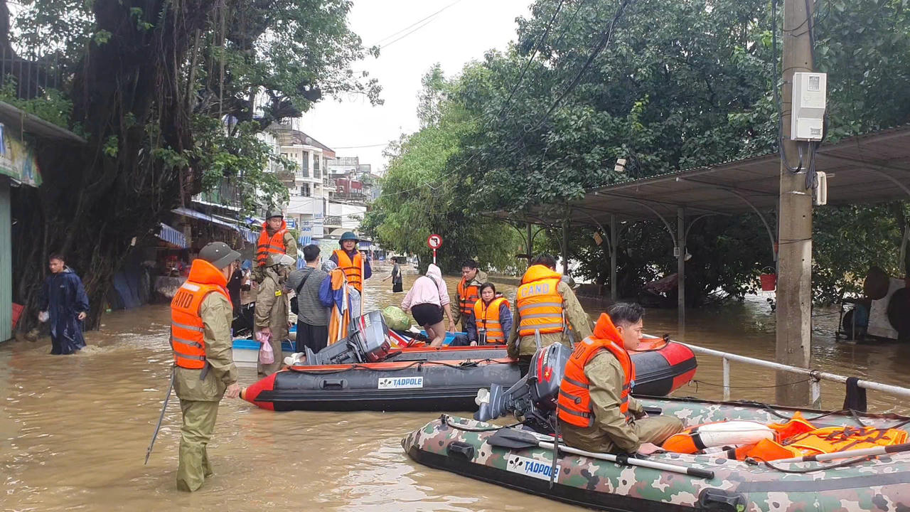 Lực lượng chức năng hỗ trợ người dân vùng thấp trũng đến vị trí an toàn. Ảnh: CACC.