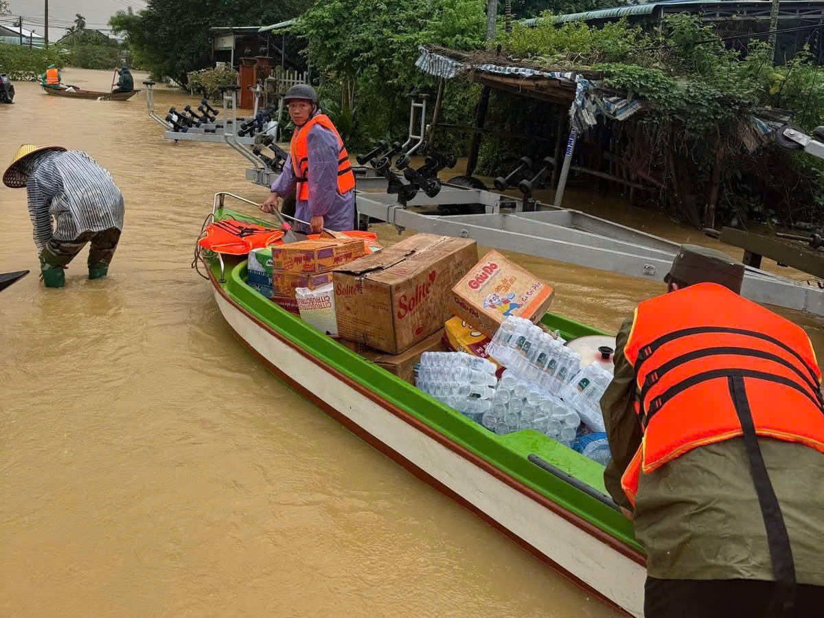 Đưa lương thực cứu trợ vào vùng ngập xã Duy Nghĩa. Ảnh: Thu Giang.