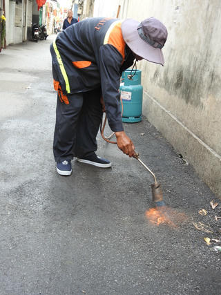 Đà Nẵng: Khò lửa ga để vá lại đường vừa thảm nhựa đã bong tróc do mưa 