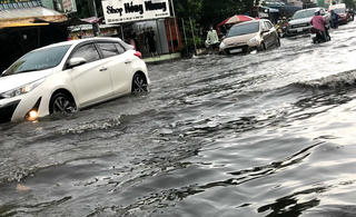 Người dân TP HCM bì bõm di chuyển trong mưa lớn và triều cường