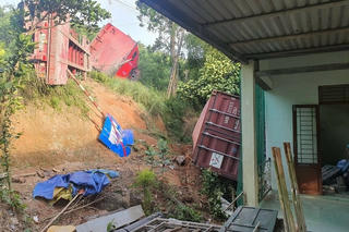 Xe đầu kéo bị lật trên Quốc lộ, thùng container bay vào nhà dân