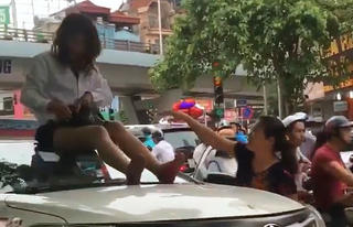 Nữ tài xế taxi mặc váy ngồi nóc ô tô chống đối CSGT