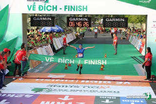 Các VĐV chúc mừng ông Đoàn Ngọc Hải về đích tại giải marathon Hậu Giang
