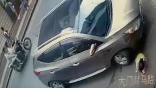 Bé gái đứng dậy sau khi bị ô tô chèn qua người