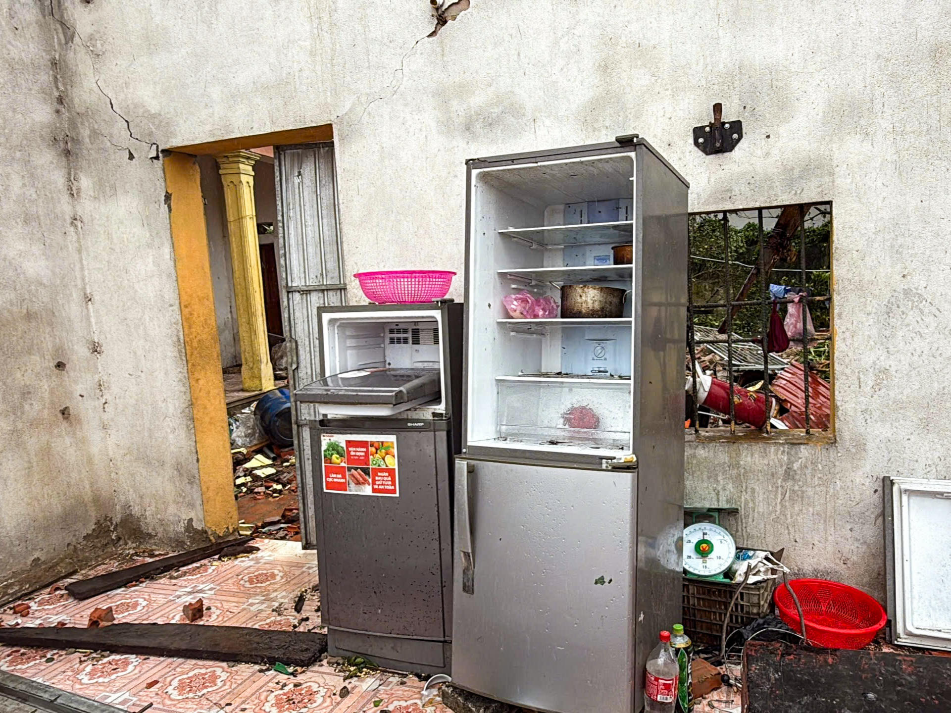 "Gió lốc cuốn bay mái nhà chính, bay luôn mái tôn nhà bếp, giờ trong nhà chỉ còn trơ trọi ít đồ đạc. Giờ nơi ăn, nơi ở đều không có, rất khổ. Khi bão đến, mình cũng không nghĩ nó sẽ tàn phá kinh khủng như vậy", bà Hiển ngậm ngùi nói. Ảnh: Đình Minh.