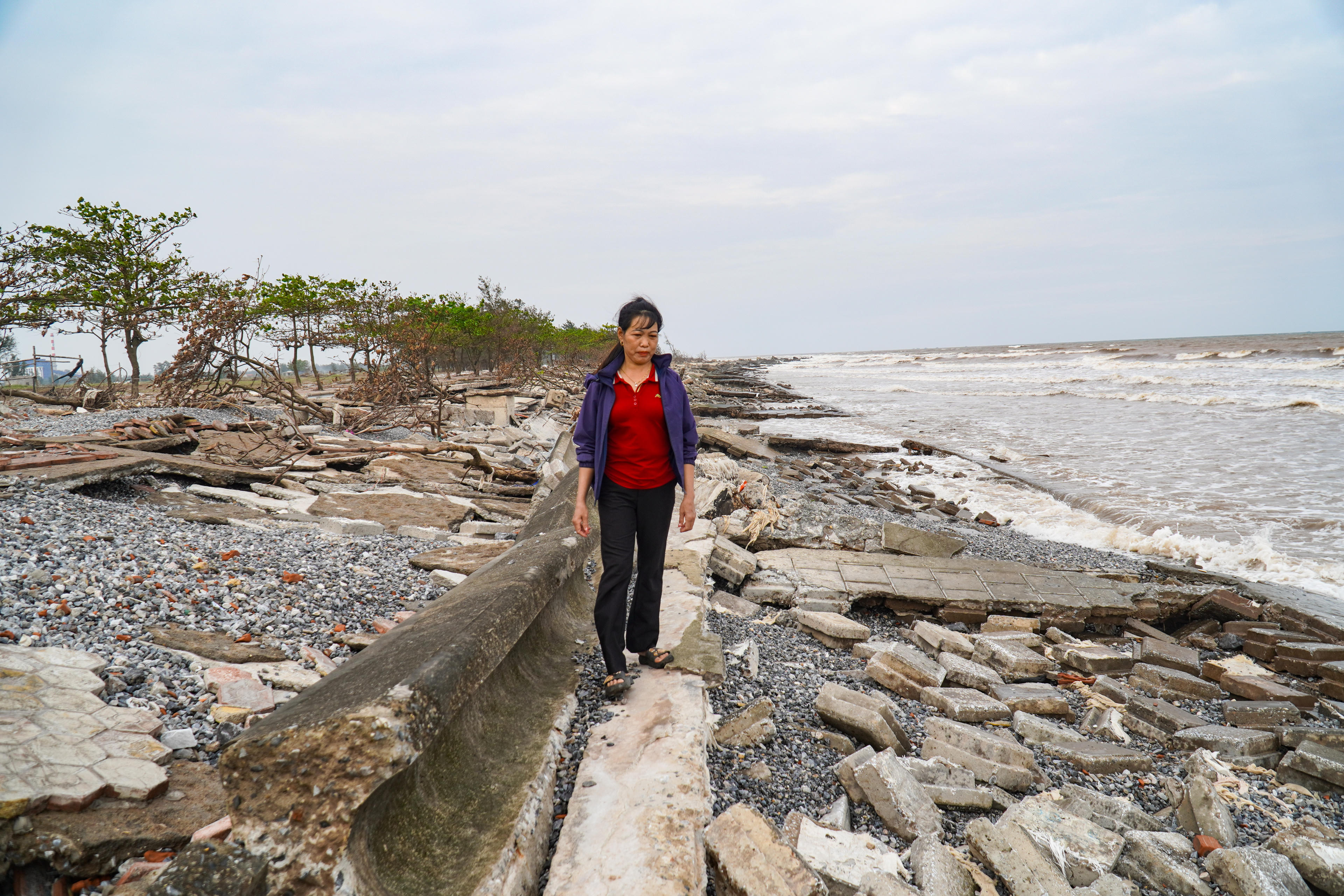 Bà Vũ Thị Nhung, trú thôn 2, xã Rạng Đông cho biết: Sau khi kè biển bị sóng đánh vỡ nát, gia đình bà cùng một số hộ kinh doanh dịch vụ du lịch ven bờ phải ngừng hoạt động, di dời đồ đạc do lo ngại sạt lở lan sâu vào bờ. Ảnh: Đình Minh.