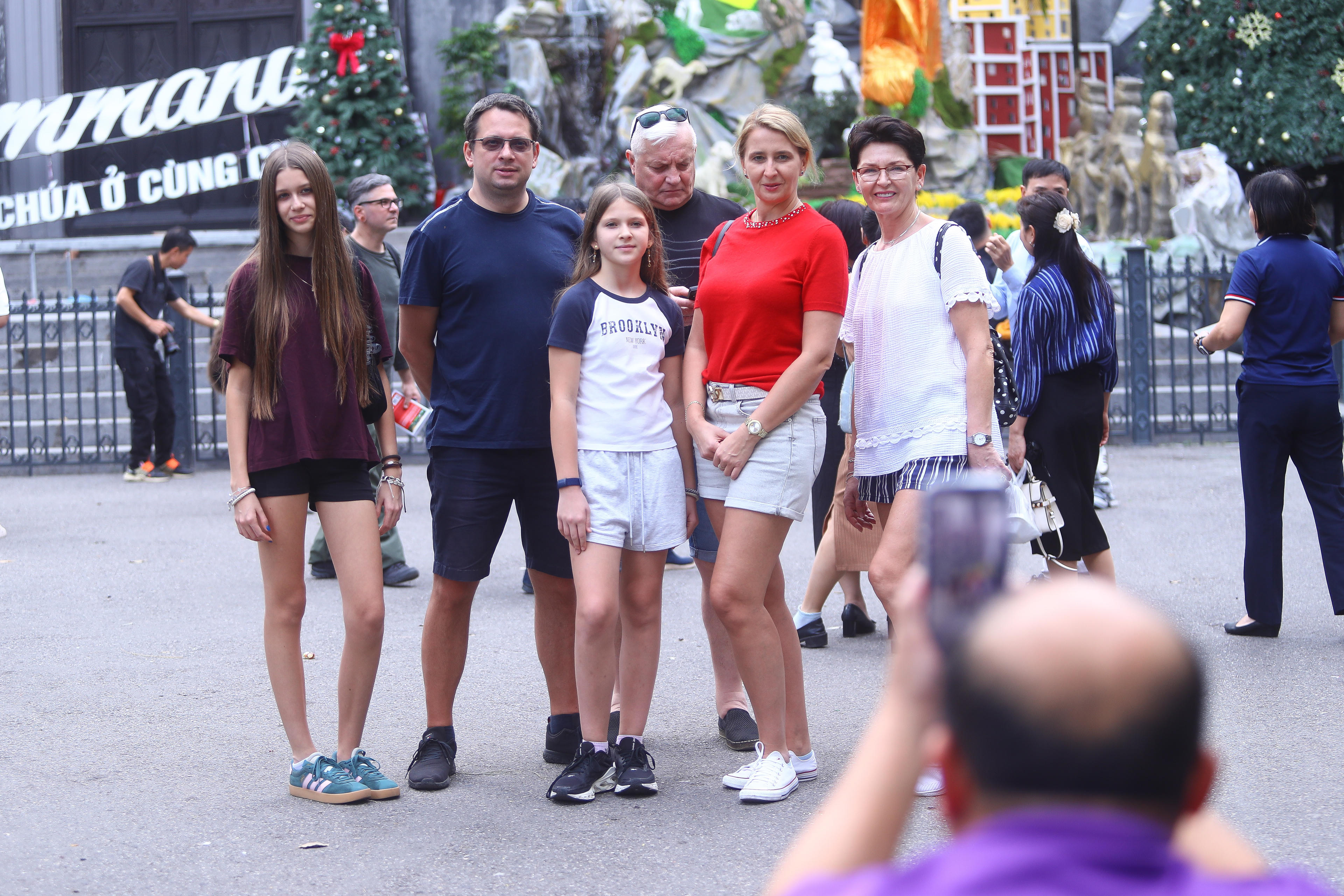 Du khách tản bộ quanh quảng trường, tranh thủ lưu lại những khoảnh khắc kỷ niệm, trong khi nhiều gia đình đưa trẻ nhỏ đến tham quan, chụp ảnh cùng cây thông Noel và các mô hình trang trí.