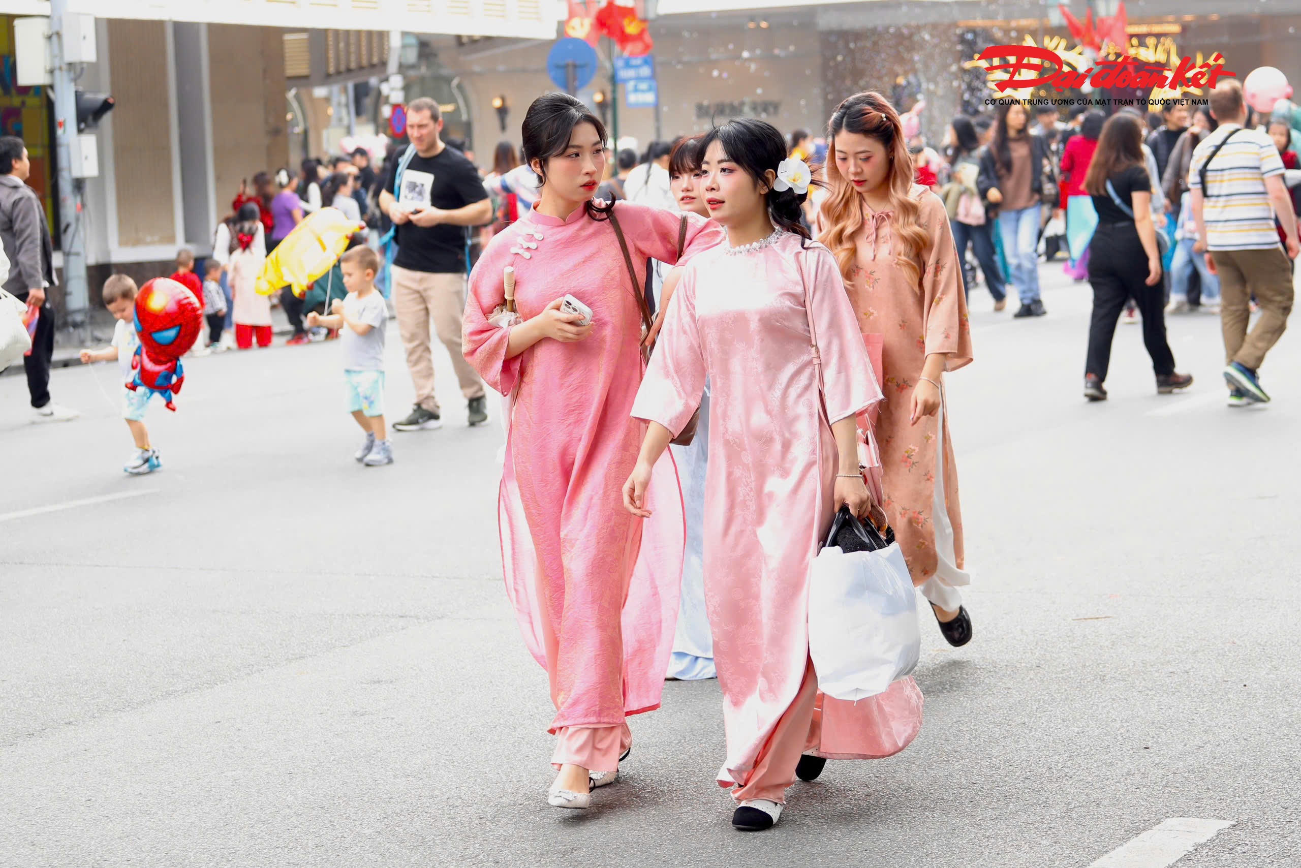 Áo dài truyền thống kết hợp cùng phụ kiện hiện đại, khăn vấn, hoa tươi hay máy ảnh đã tạo nên bức tranh giao thoa hài hòa giữa nét đẹp văn hóa truyền thống và nhịp sống trẻ trung của Thủ đô.