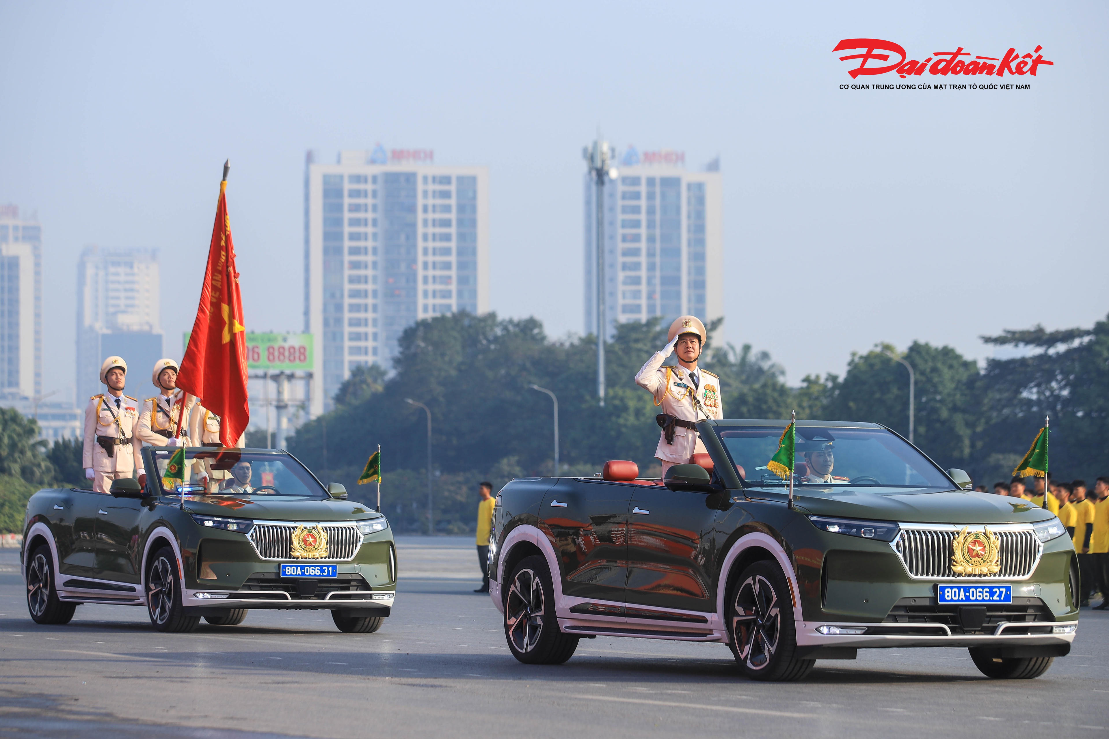 Thiếu tướng Lê Văn Sao - Phó tư lệnh Cảnh sát cơ động (Bộ Công an) - trên xe chỉ huy dẫn đầu lực lượng duyệt đội hình bên cạnh Tổ công an kỳ, mang theo lá cờ truyền thống với dòng chữ "Bảo vệ an ninh Tổ quốc