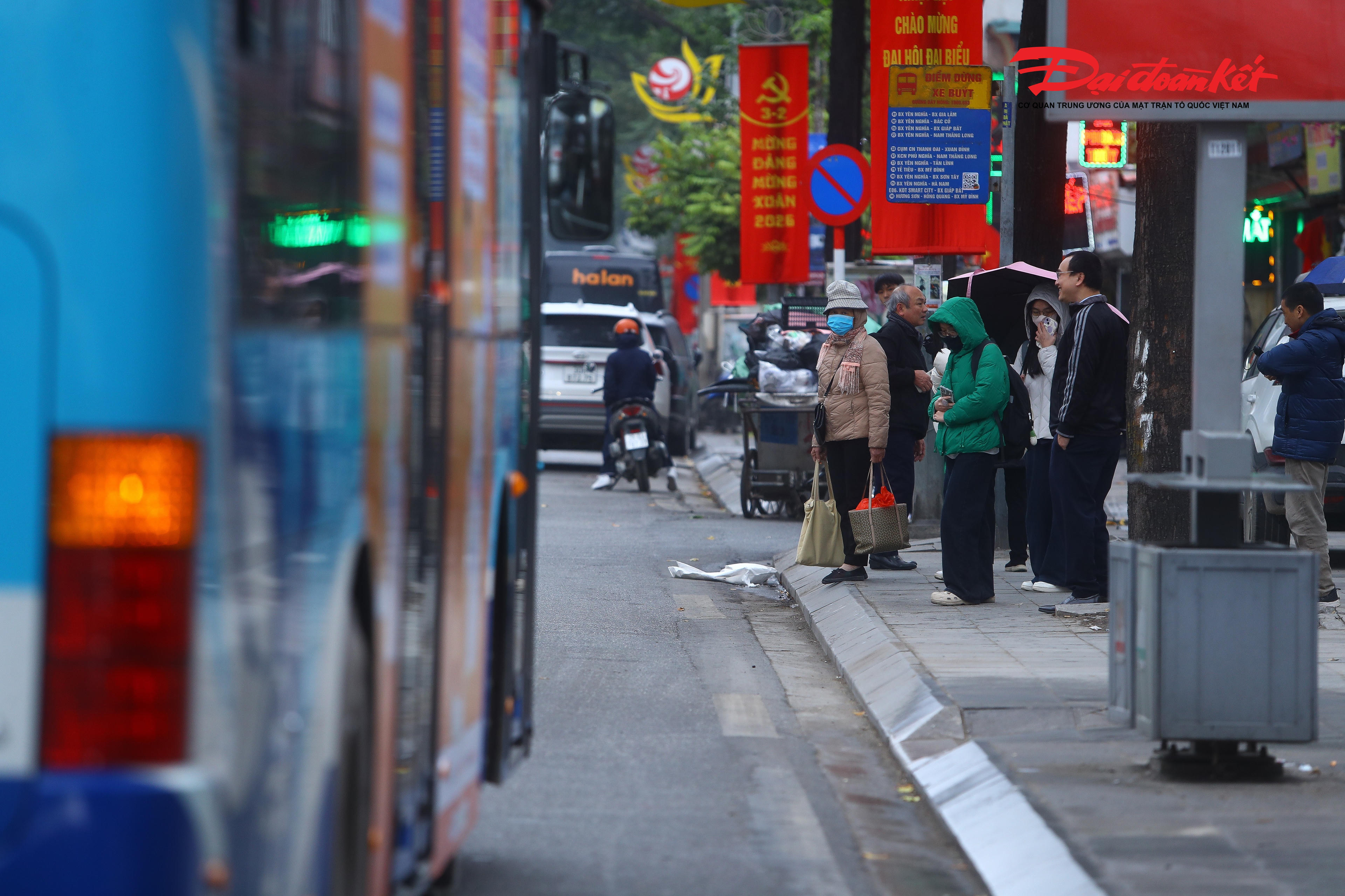 Trong cái rét 9 độ C kèm mưa nhỏ, nhiều người dân co ro đứng chờ xe buýt, khoác chặt áo mưa và áo ấm để tránh gió lạnh.