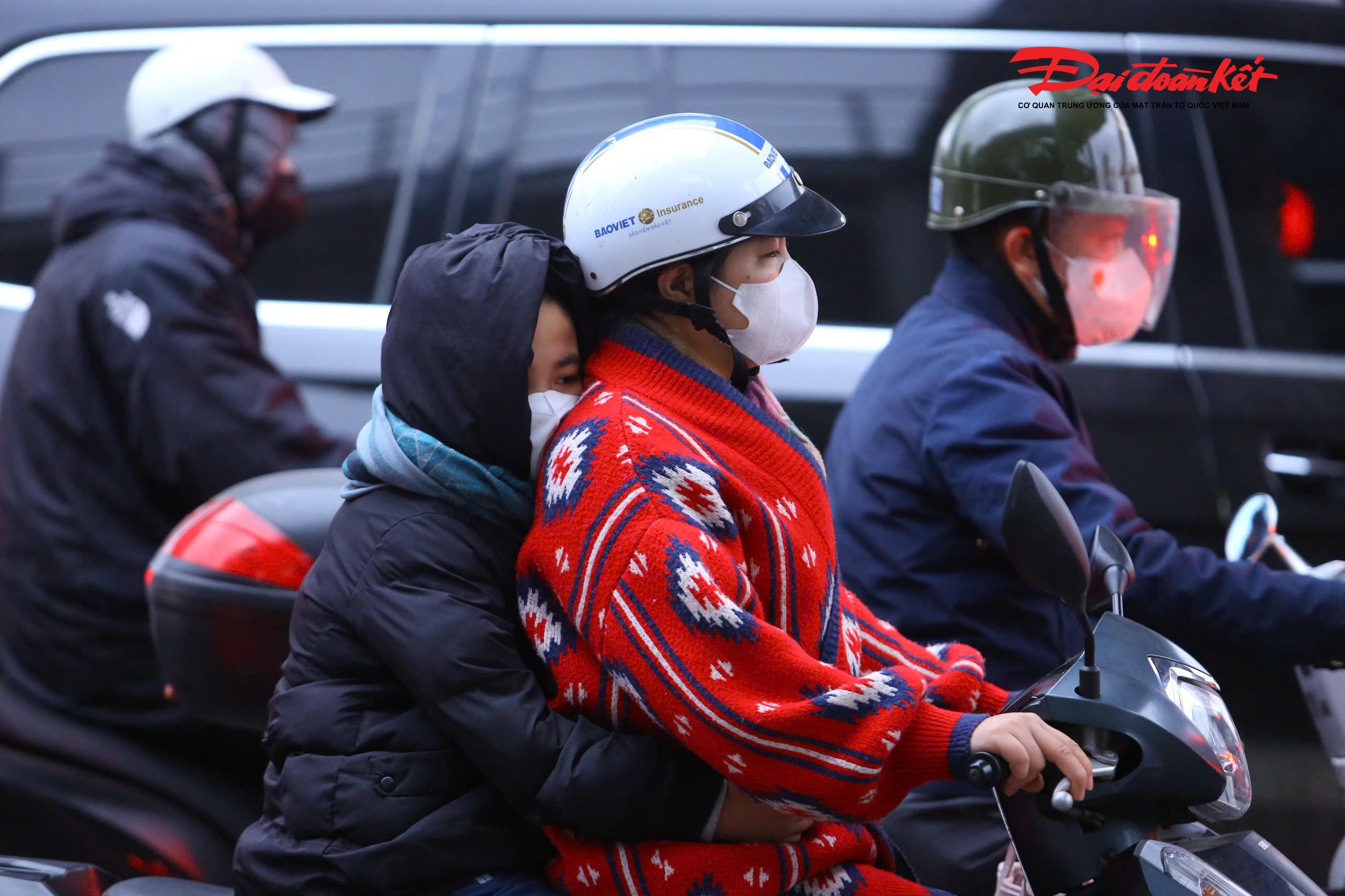 Trong cái giá rét buổi sáng, nhiều em nhỏ nép sát vào mẹ trên đường đến trường.