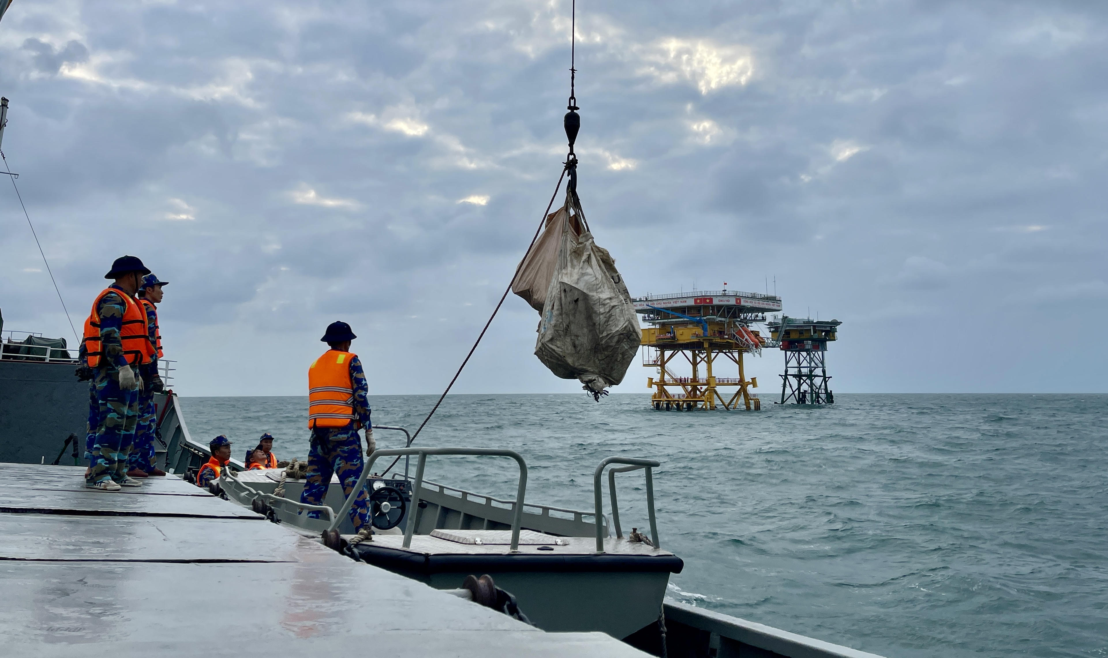 Hàng hoá được vận chuyển từ tàu lớn sang ca nô nhỏ để chuẩn bị tiếp cận nhà giàn. Ảnh: Đoàn Xá.