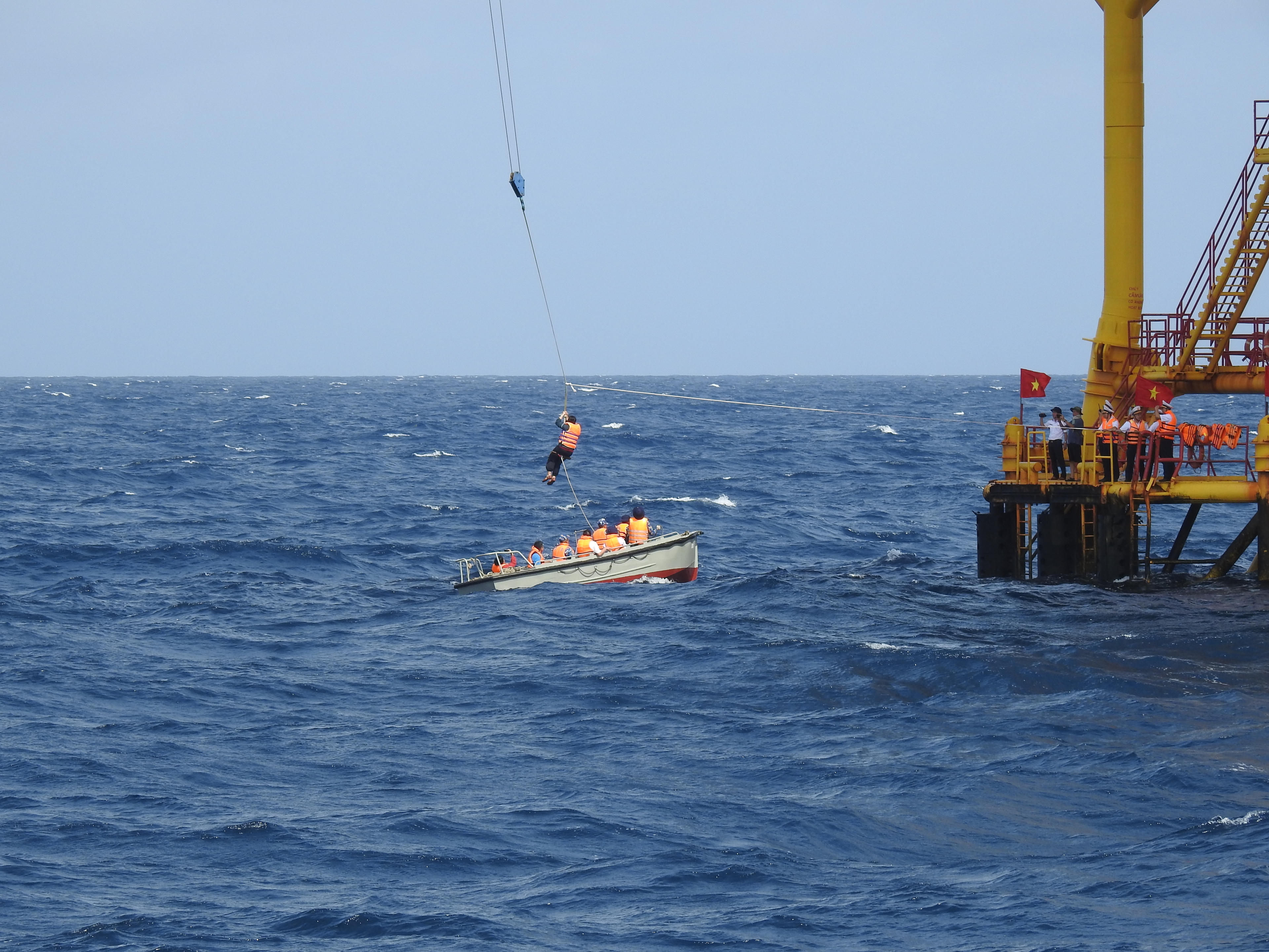 Từng thành viên đoàn công tác vượt sóng gió để đem quà tết từ đất liền tới các cán bộ chiến sỹ nhà giàn DK1. Ảnh: Đoàn Xá.