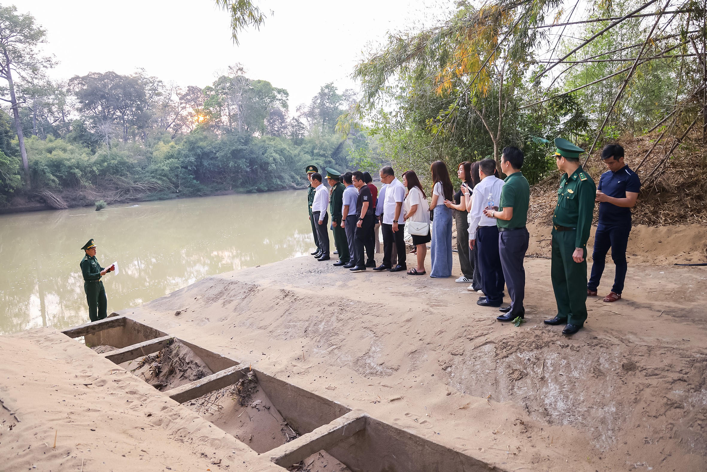 Đoàn công tác nghe giới thiệu về Bến phà vượt sông Sêrêpốk – Di tích lịch sử quốc gia đặc biệt. Ảnh: Quang Vinh.