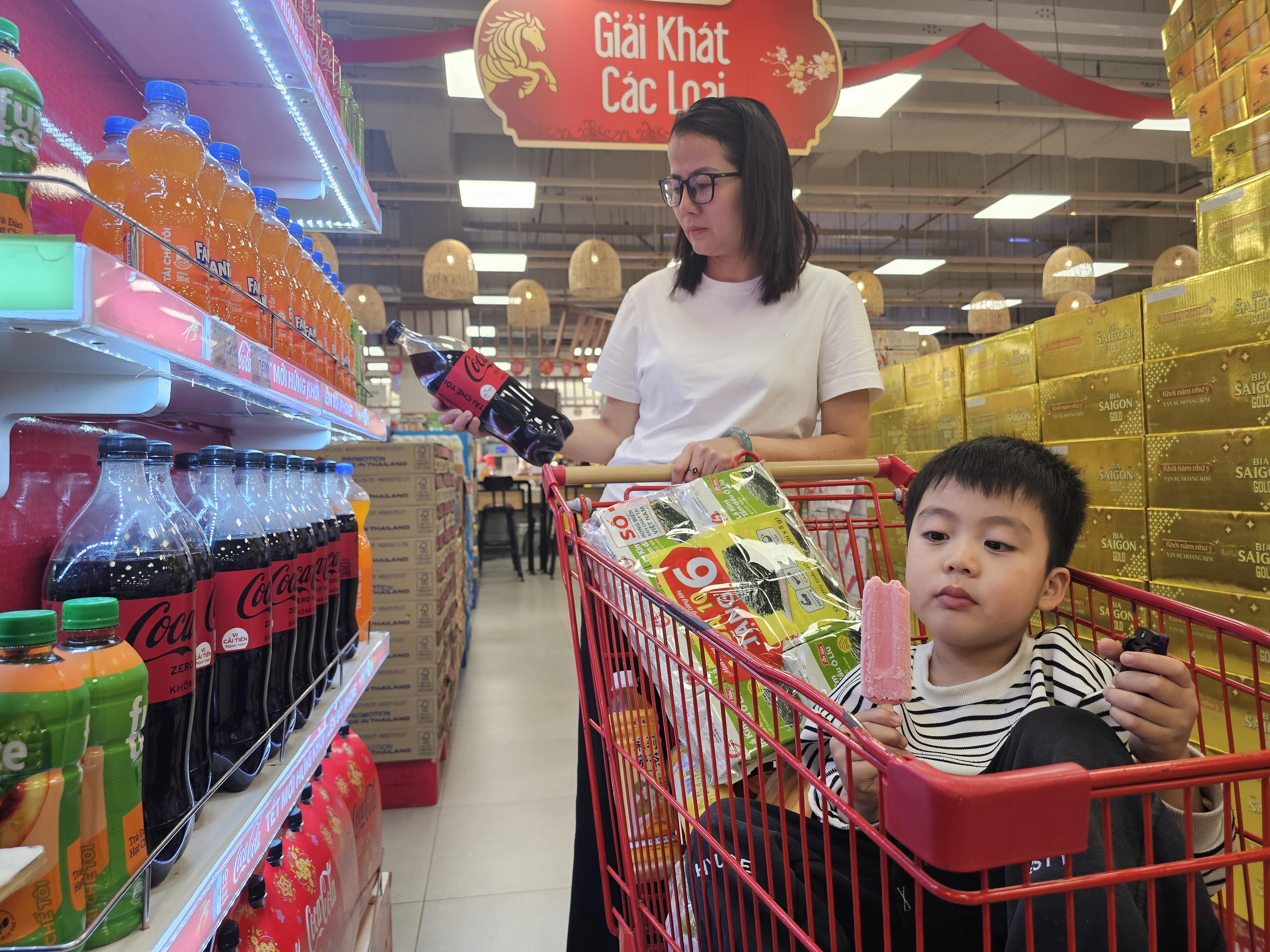 Một em bé theo mẹ đi sắm Tết sớm.&nbsp;Ảnh: Quốc Thanh.