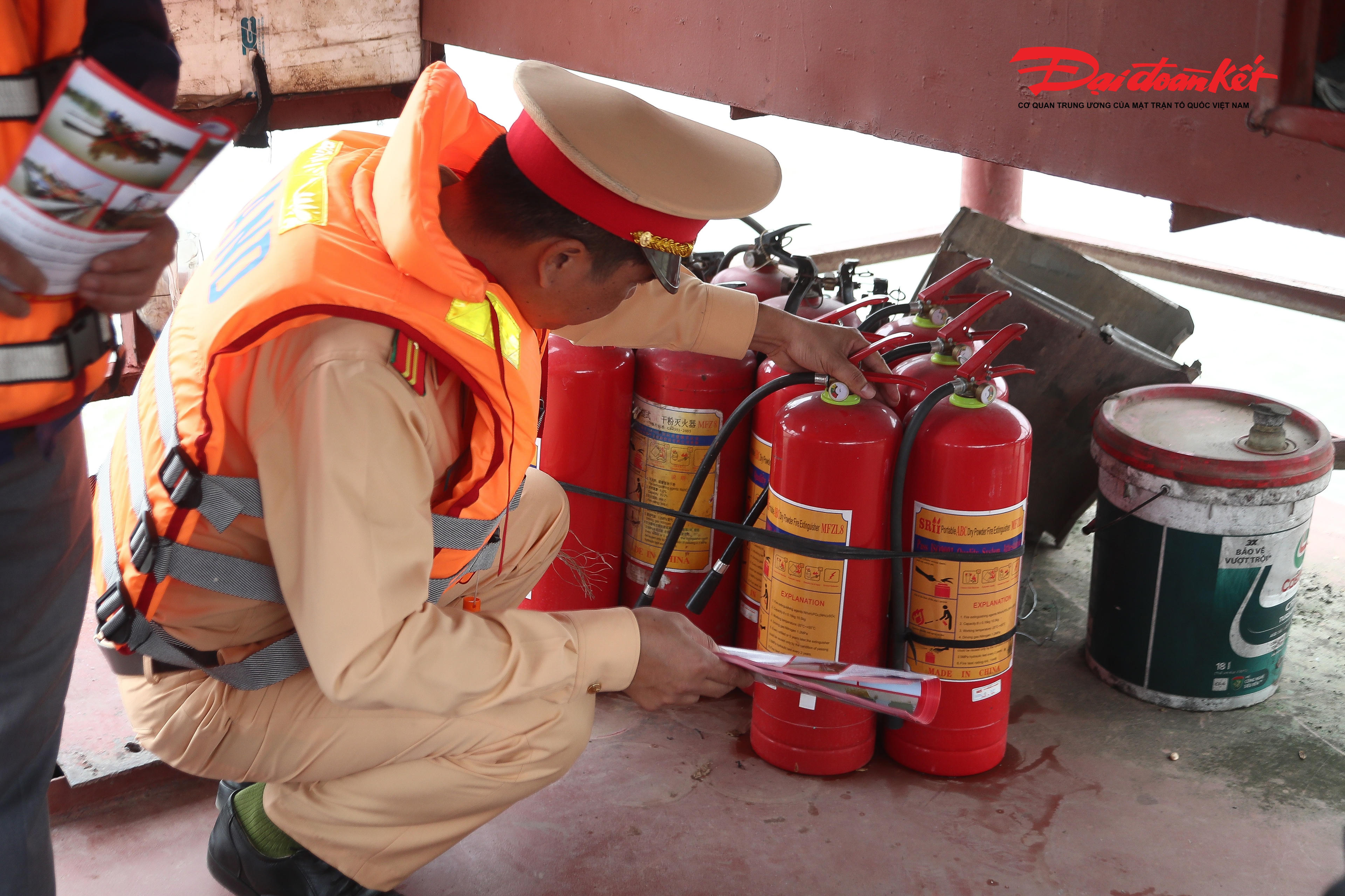 Cảnh sát giao thông kiểm tra trang bị bình chữa cháy trên phà chở khách ngang sông, bảo đảm các điều kiện an toàn trước khi phương tiện hoạt động.