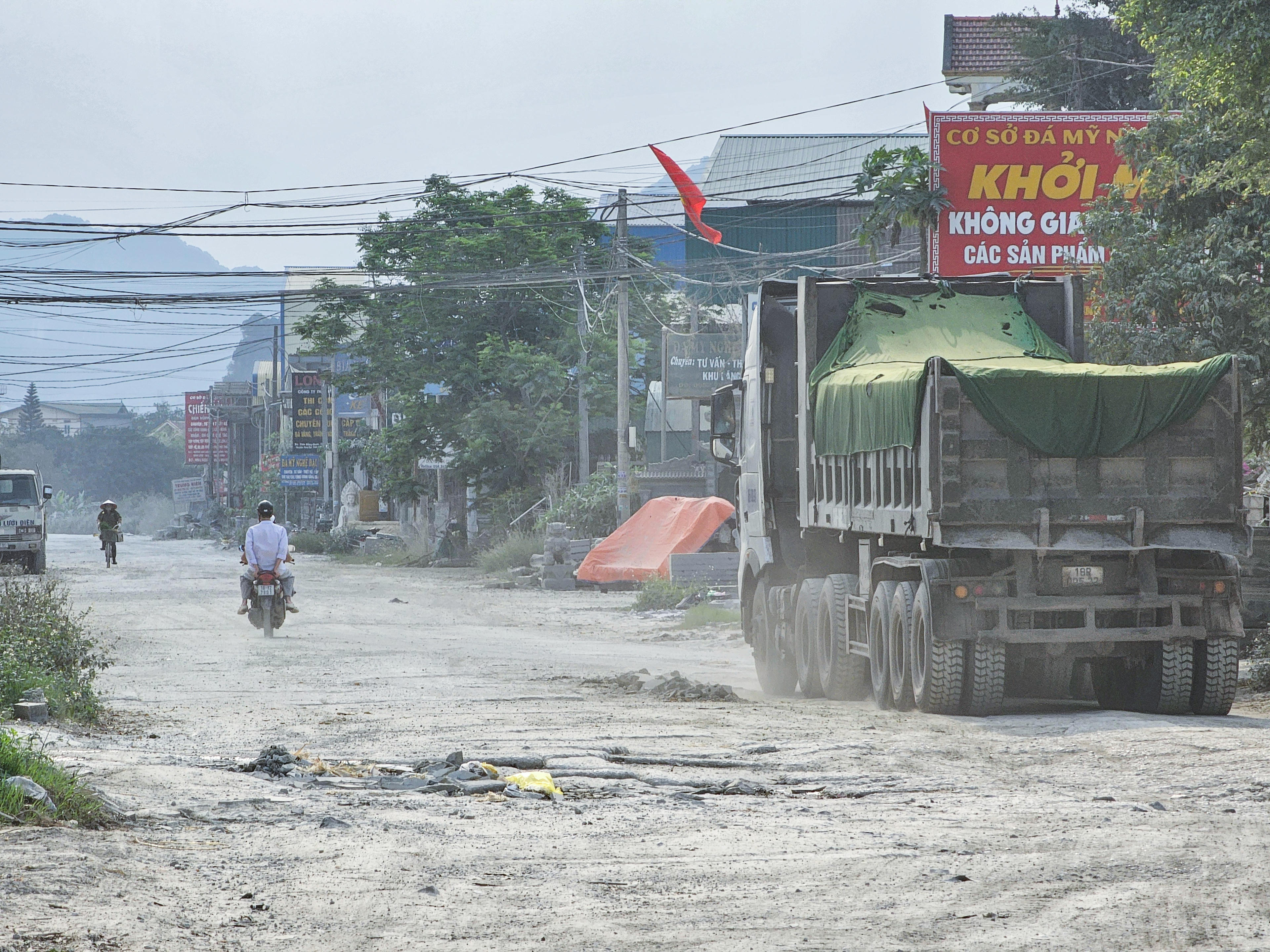 Ông Phạm Ngọc Vĩnh (53 tuổi, trú tổ dân phố Vũ Xá) cho biết: Hàng ngày, các loại xe chở vật liệu xây dựng, xi măng tải trọng lớn liên tục di chuyển qua đường Đài Loan, khiến đường vốn đã hỏng lại càng hỏng thêm. 'Trước kia, khi đi từ khu trung tâm ra đường lớn, mọi người thường đi đường này vì ngắn và nhanh, nhưng giờ qua đây, ai cũng sợ hãi, bất an vì đường nát bét, nắng thì bụi, mưa thì trơn trượt, bất cẩn là nằm đo đường ngay', ông Vĩnh nói. Ảnh: Đình Minh