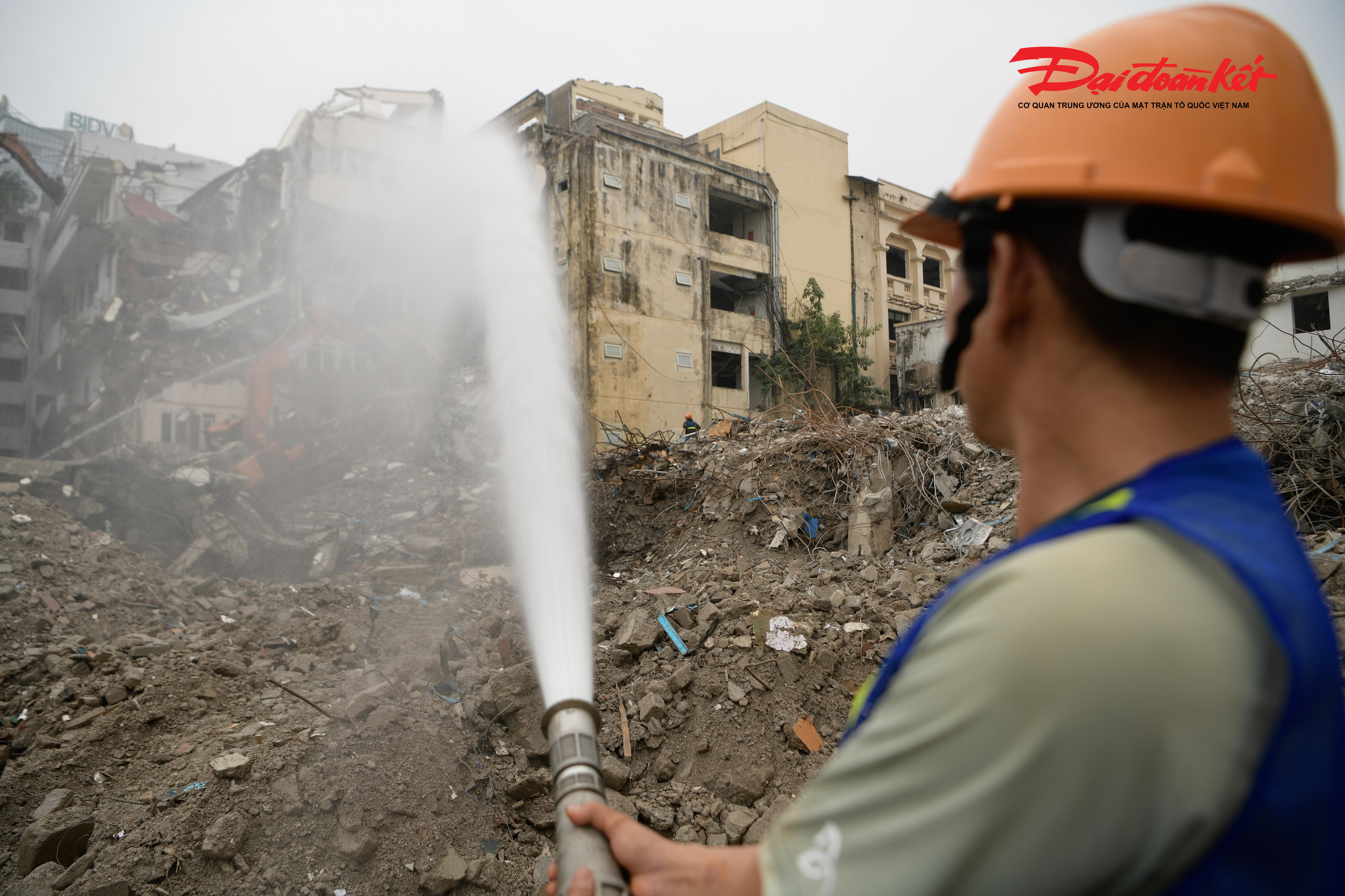 Công nhân lắp đặt hệ thống vòi phun nước công suất lớn, thường xuyên tưới ẩm khu vực thi công nhằm hạn chế bụi phát tán, giảm thiểu ảnh hưởng đến không gian xung quanh, đặc biệt trong điều kiện khu vực nằm giữa trung tâm đông đúc.